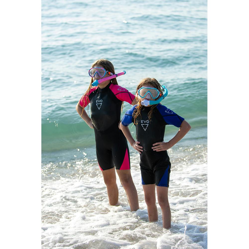 Two girls in the water wearing the blue and pink EVO Kid's Shorty wetsuits, masks, and snorkels